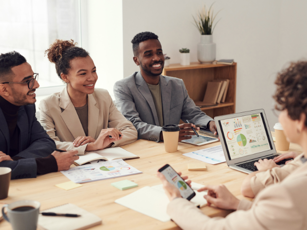 Professionals seated around a conference table discussing new strategies, replacing outdated best practices with innovative next practices to reflect adaptability in modern legal departments.