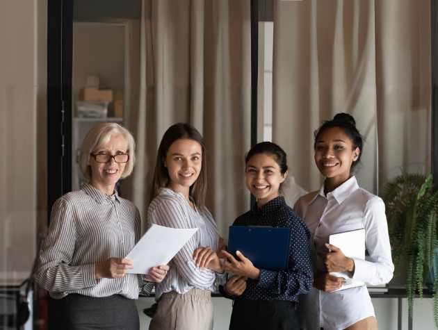 A diverse group of confident professionals standing together and smiling, representing leadership and reinvention within a legal department.